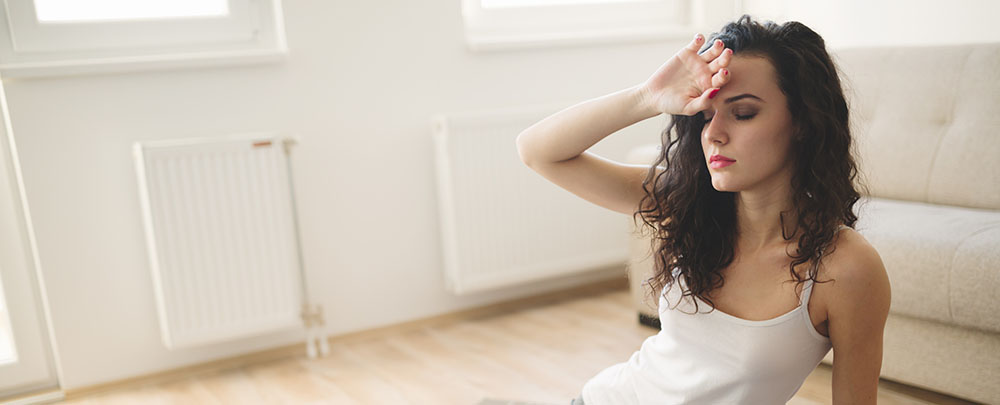 Mujer con pelo rizado tocándose la frente
