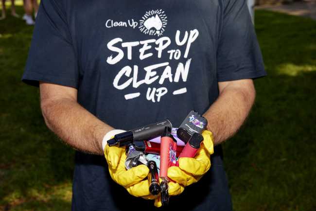 Clean Up Australia volunteer holding littered vapes