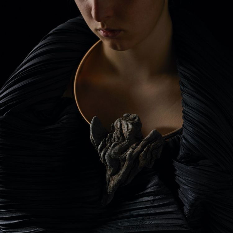 A torque necklace with a large wooden section reminiscent of an eagle