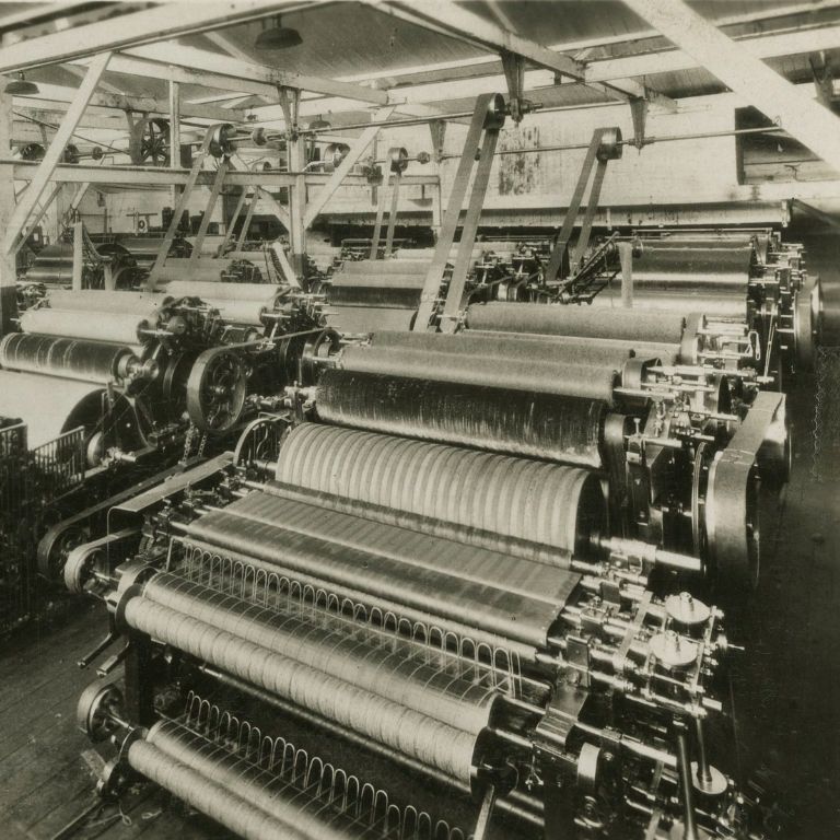 A black and white photo showing old weaving machines