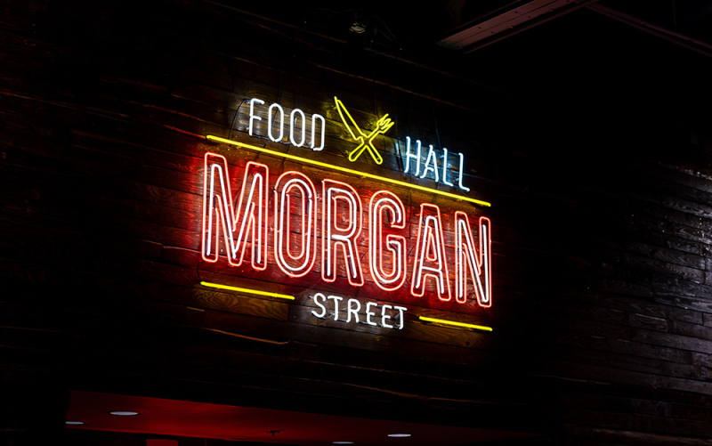 A neon sign showing the Morgan Street Food Hall logo.