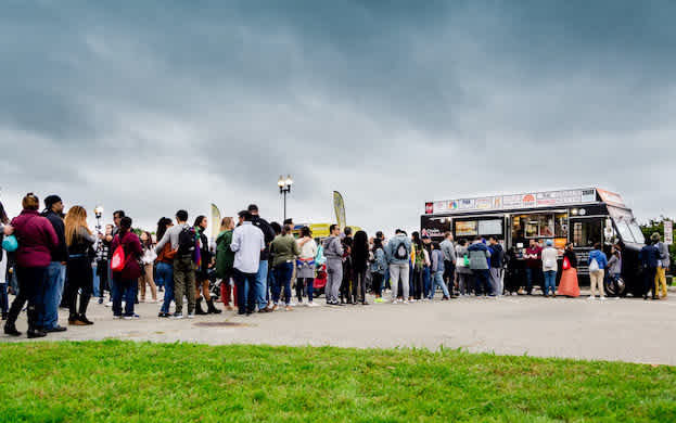 A long line of customers waiting to order from a Cousins Maine Lobster food truck.