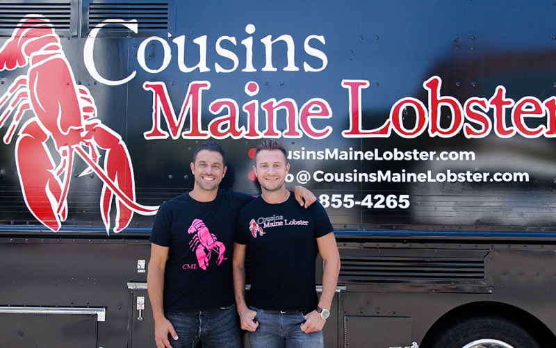 A photo of Jim & Sabin standing in front of a food truck 