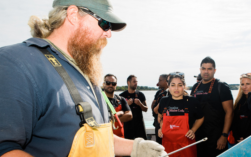 The owners of Cousins Maine Lobster Houston, being trained by a Maine lobsterman.