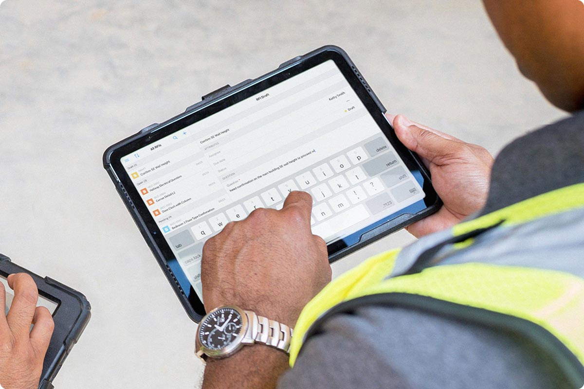 A construction worker is viewing their RFIs on an iPad. The construction worker is using the Fieldwire iOS app in the field so they always have necessary information available. 
