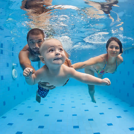 Ozone swim lifestyle image , family swimming under water with a baby