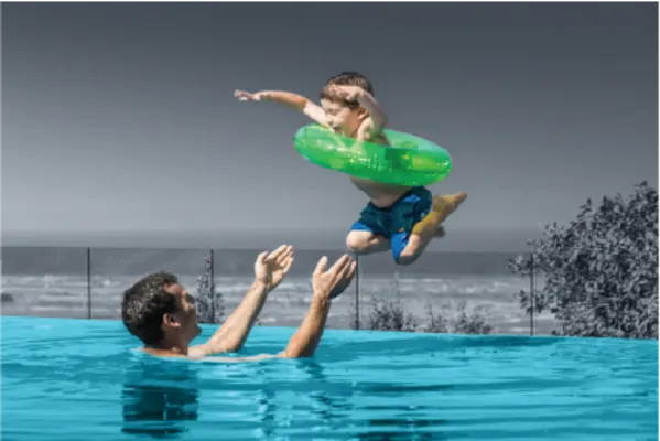 Young boy jumps to his father in the pool