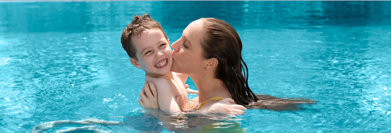Mother with son swimming in a pool after chlorination.
