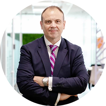 Portret al lui Radu Maftei, Senior Vice President P&G South East Europe, zâmbind și privind direct în cameră.