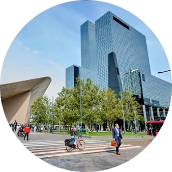 Kantoorgebouw van Procter & Gamble in Nederland, een hoge glazen toren naast een modern treinstation.