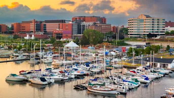 A harbor with boats in the water with buildings in the background