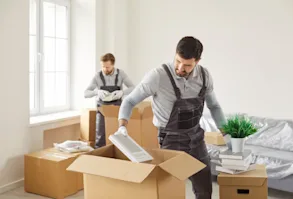 Two men packing things into boxes