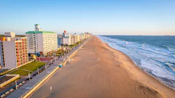 Aerial view of a beach and ocean with buildings on the left side