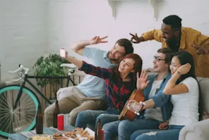 People taking a photo of themselves sitting on a couch.
