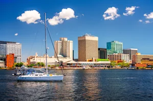 Skyline view of Chesapeake, VA with a boat in the water in the foreground and skyscrapers in the background