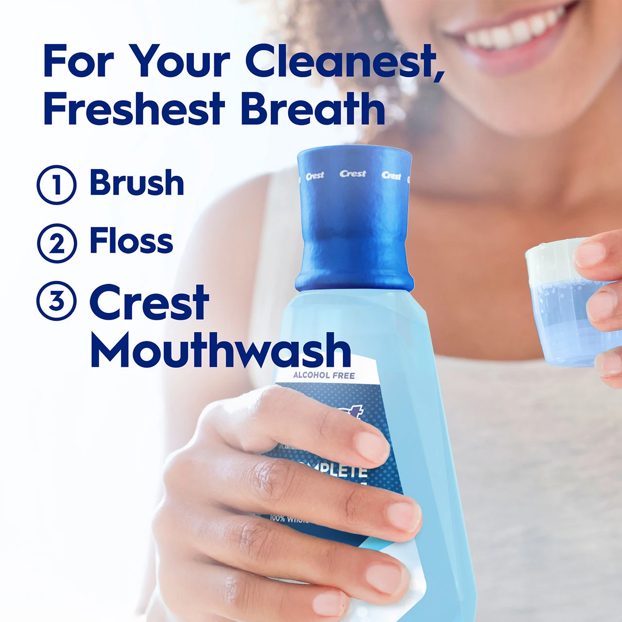 Person holding a Crest Pro‑Health mouthwash bottle and rinsing cup with text ‘For Your Cleanest, Freshest Breath’ and steps ‘1 Brush 2 Floss 3 Crest Mouthwash.