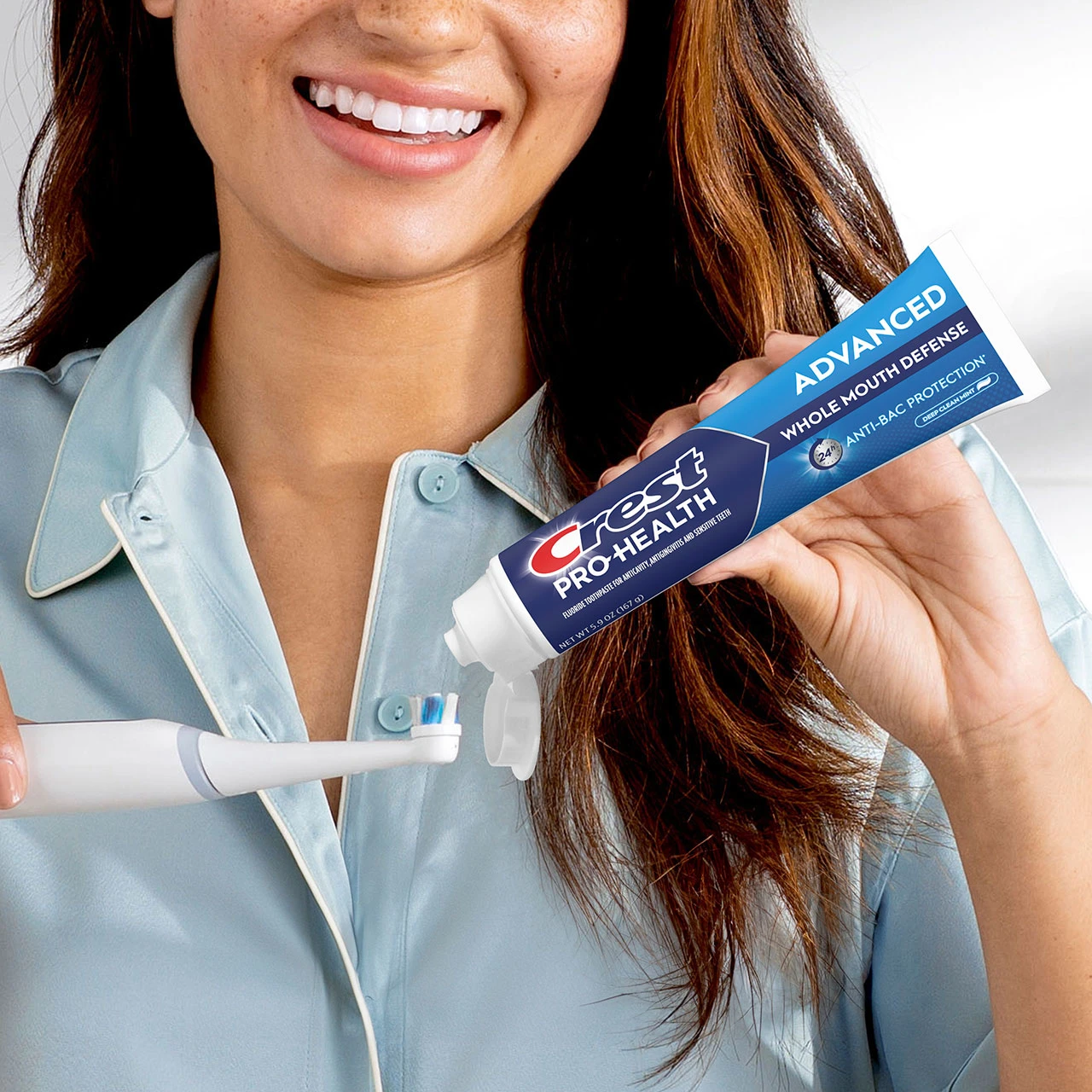 Woman using the Crest Pro-Health Advanced Whole Mouth Defense Toothpaste