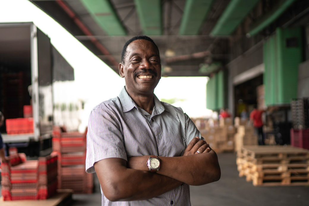 A smiling black business owner standing in a loading dock.