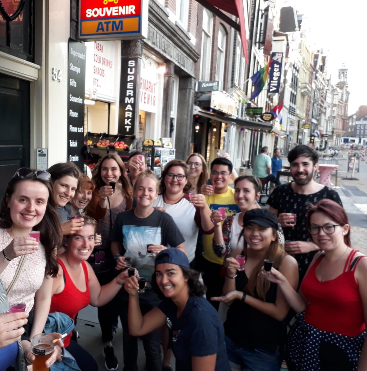 Smiling people holding shot glasses