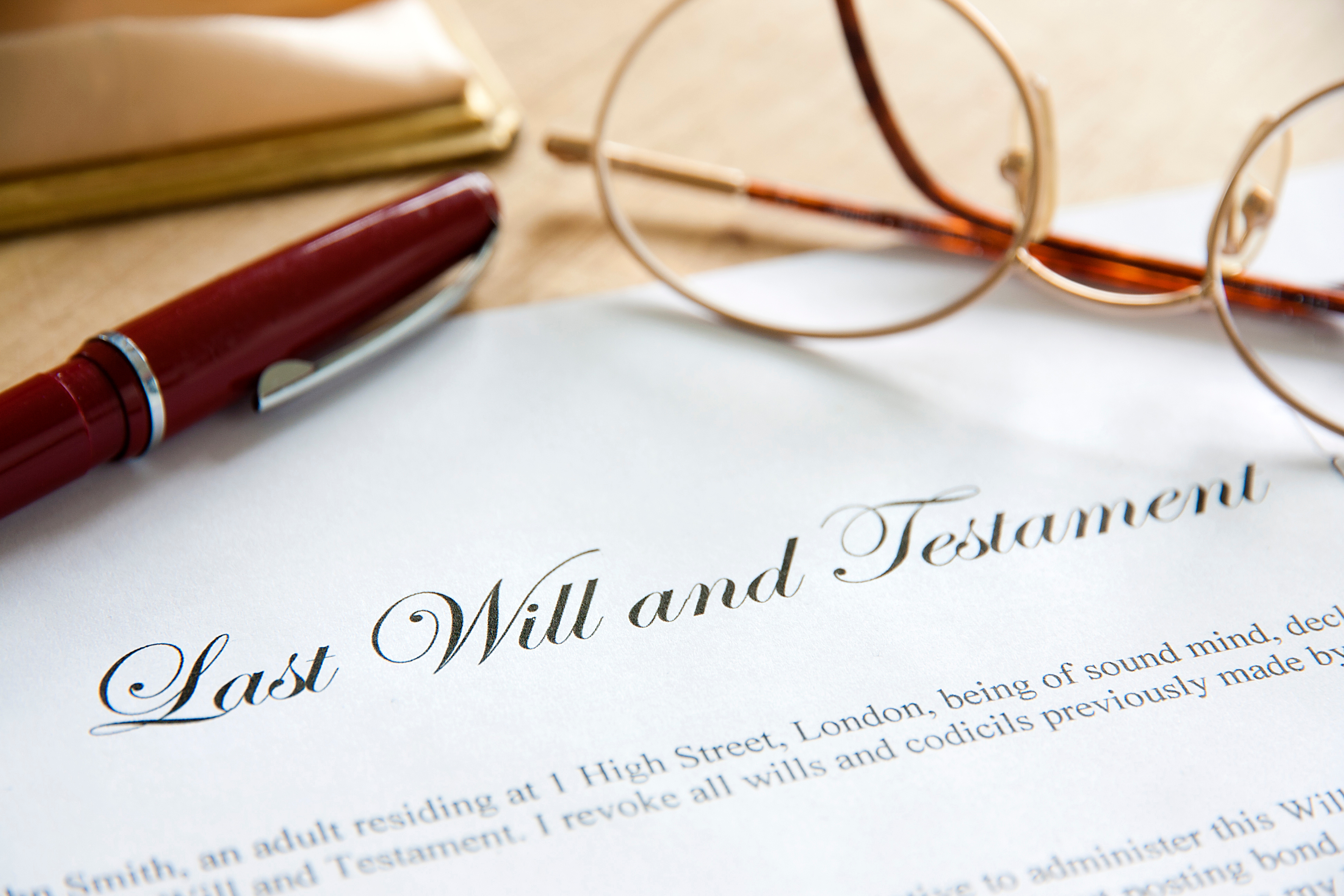 Last will and testament with pen and folded glasses