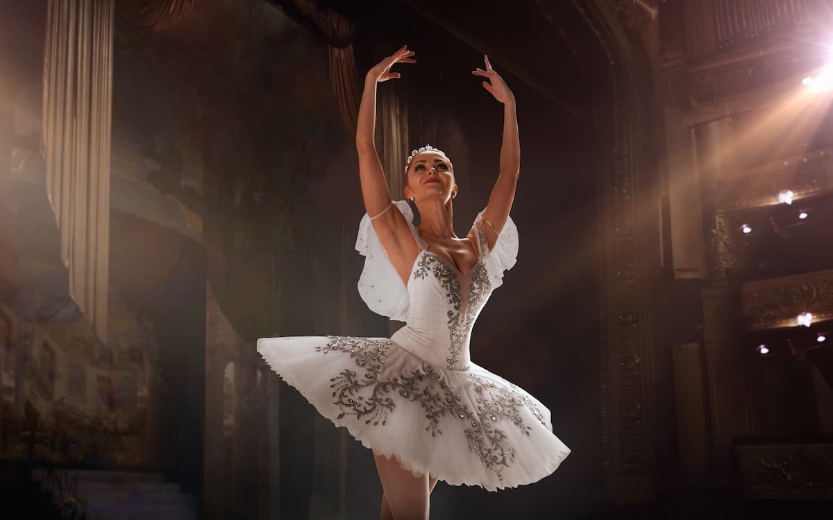 ballerina dancing on stage in ornate white tutu
