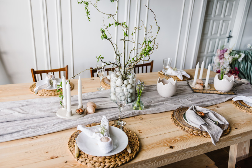 Pine dining table with woven table mats, runner and candles, with greenery centerpiece