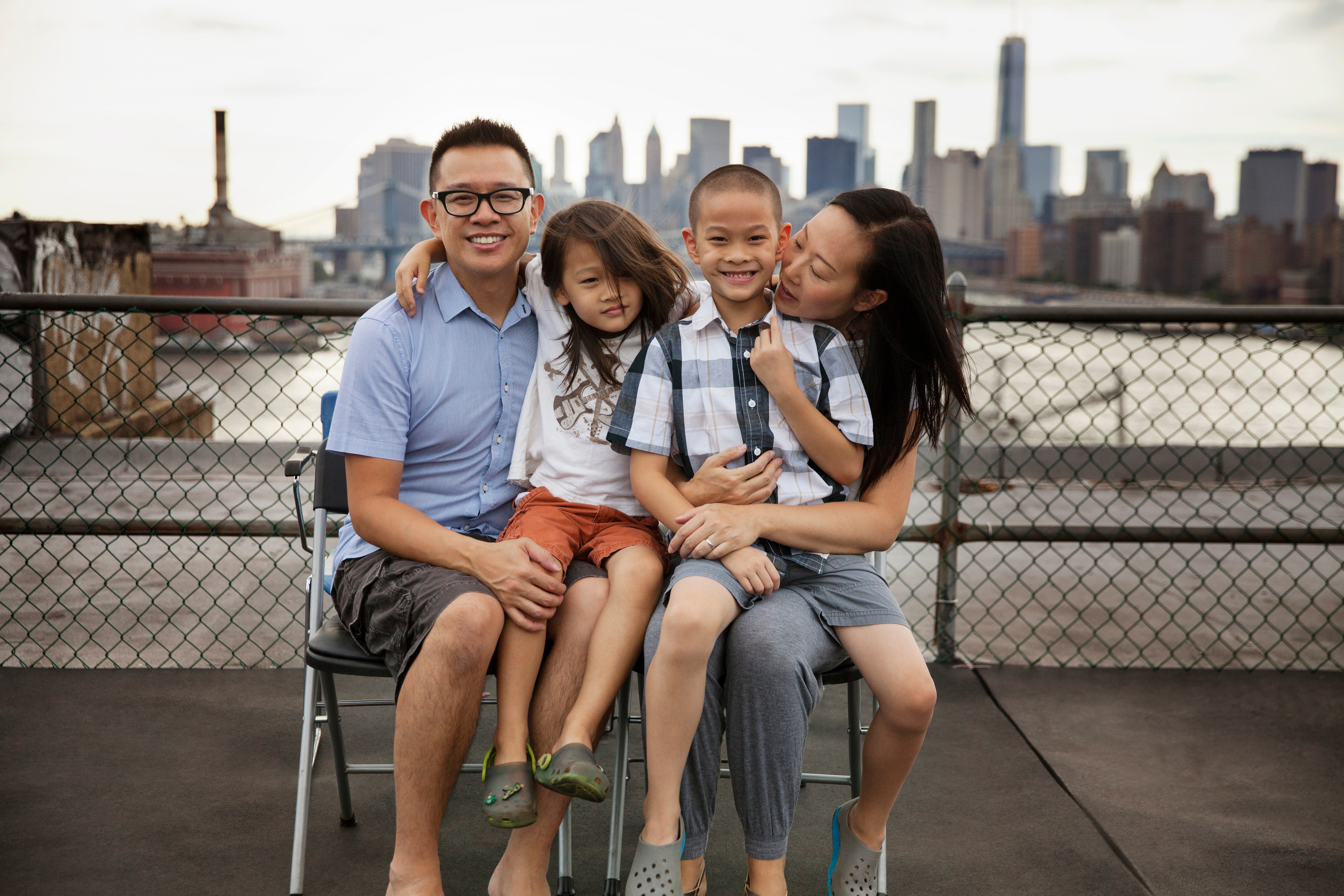 Asian family sitting on rooftop in the city