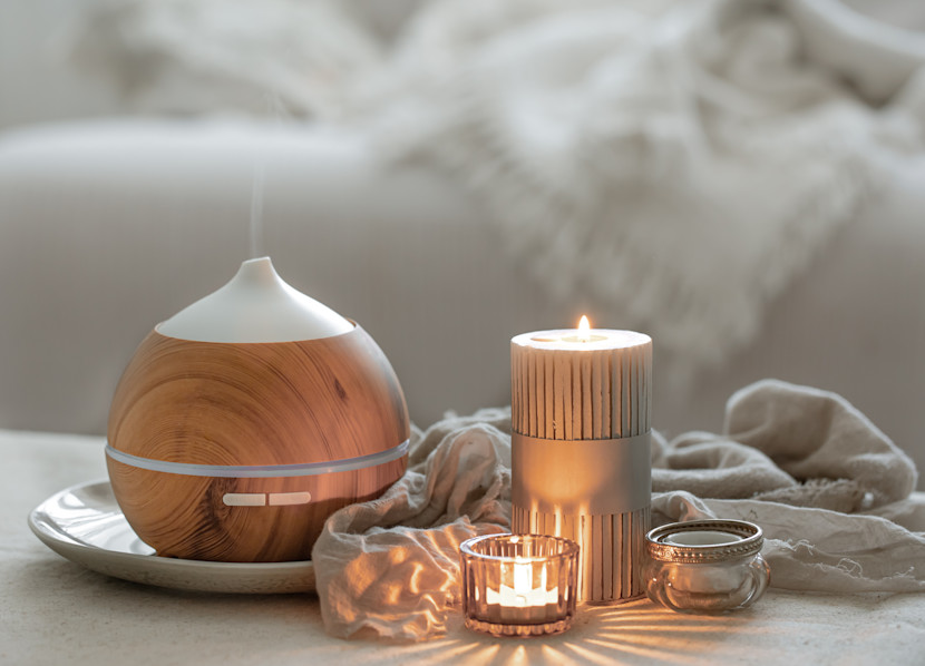 Pillar candles of different shapes, with a cozy throw in the background