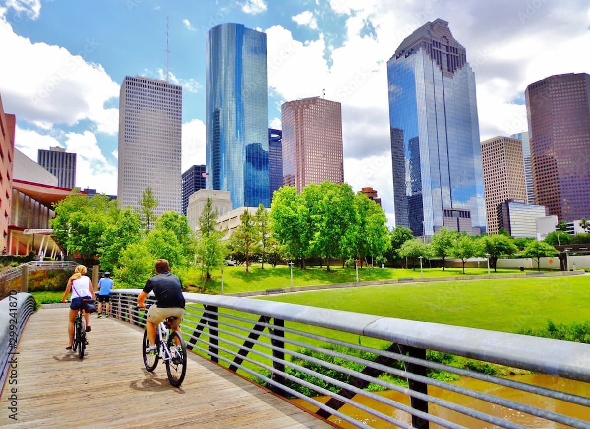bikers riding in Buffalo Bayou Park with Houston skyscrapers in sight