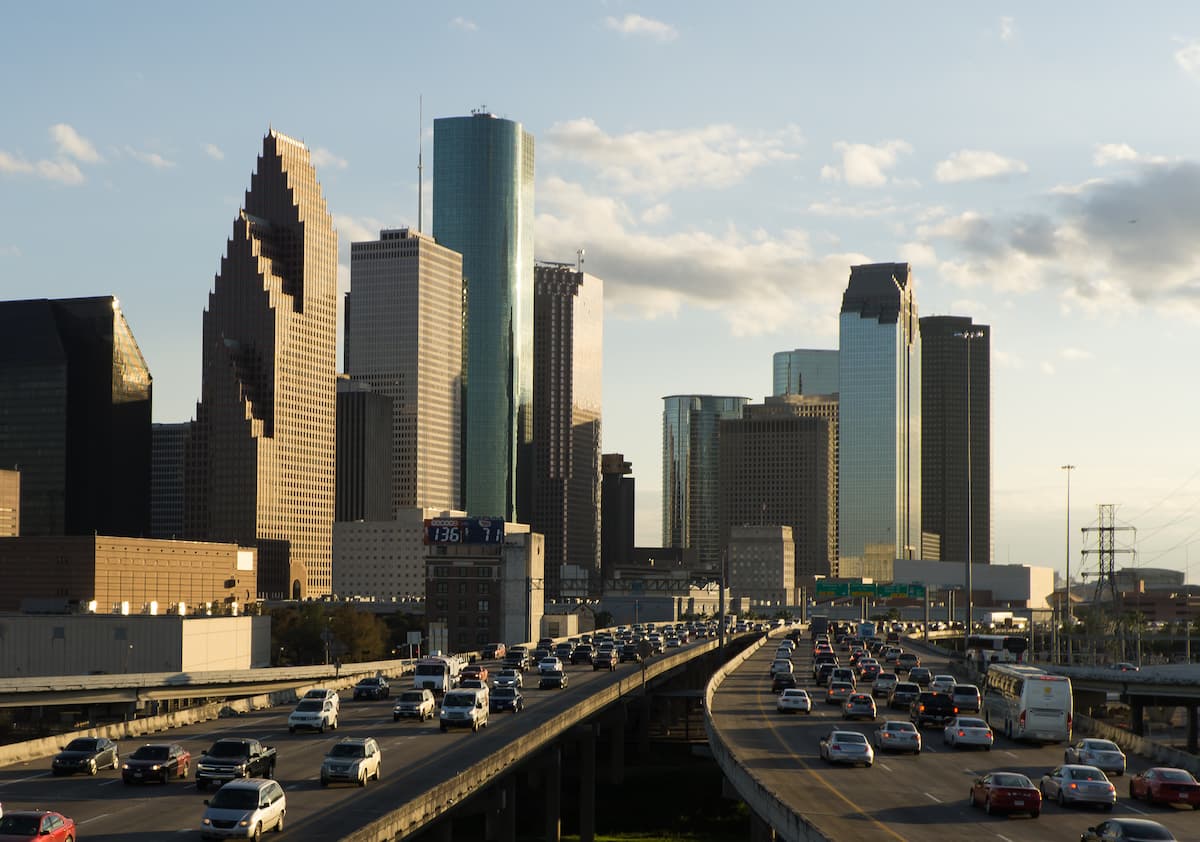 rush hour traffic on major city highways with skyscrapers in the background