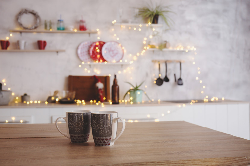 Open shelving in a kitchen with eclectic decor, wrapped in twinkle lights