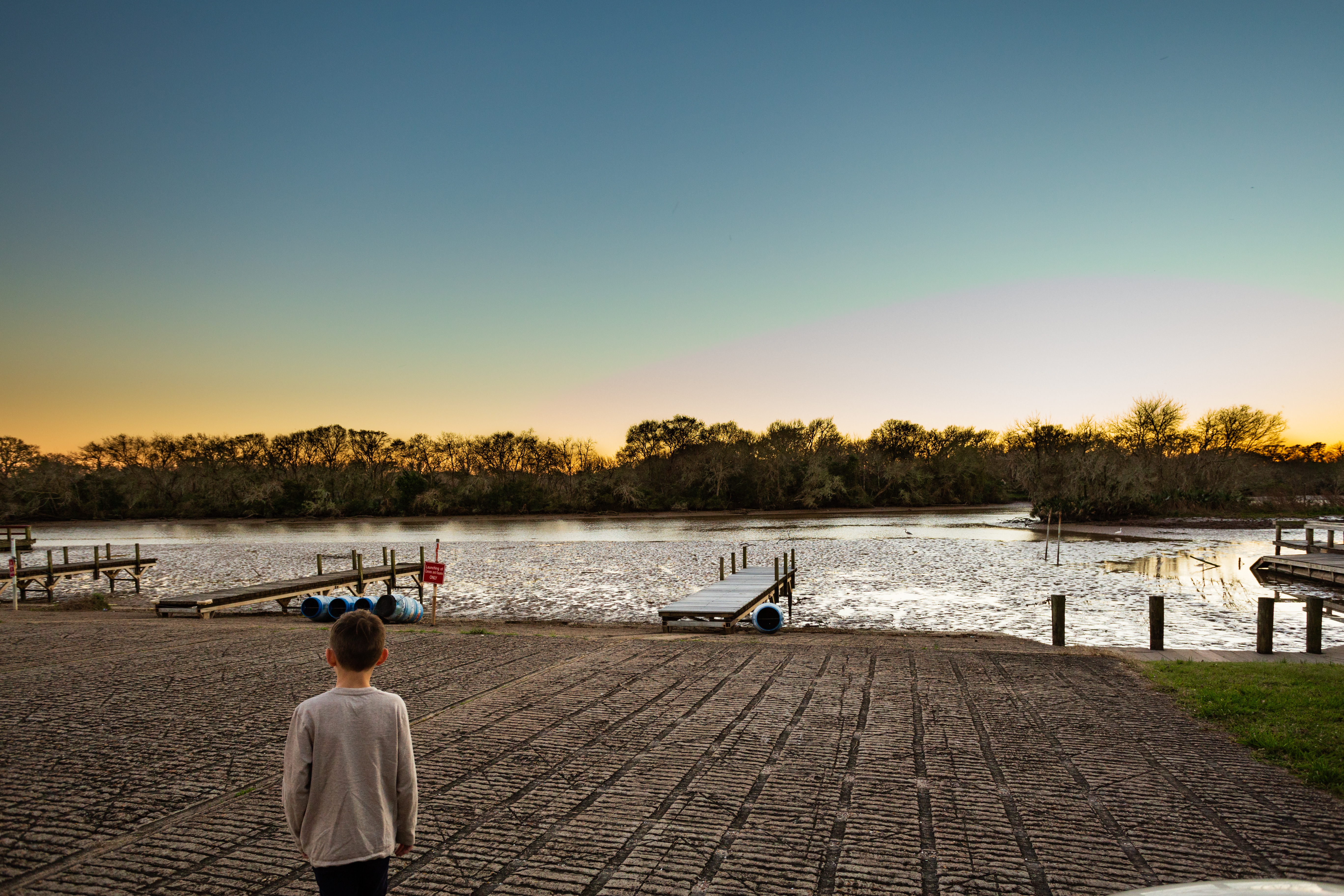 Boy overlooking a boat ramp