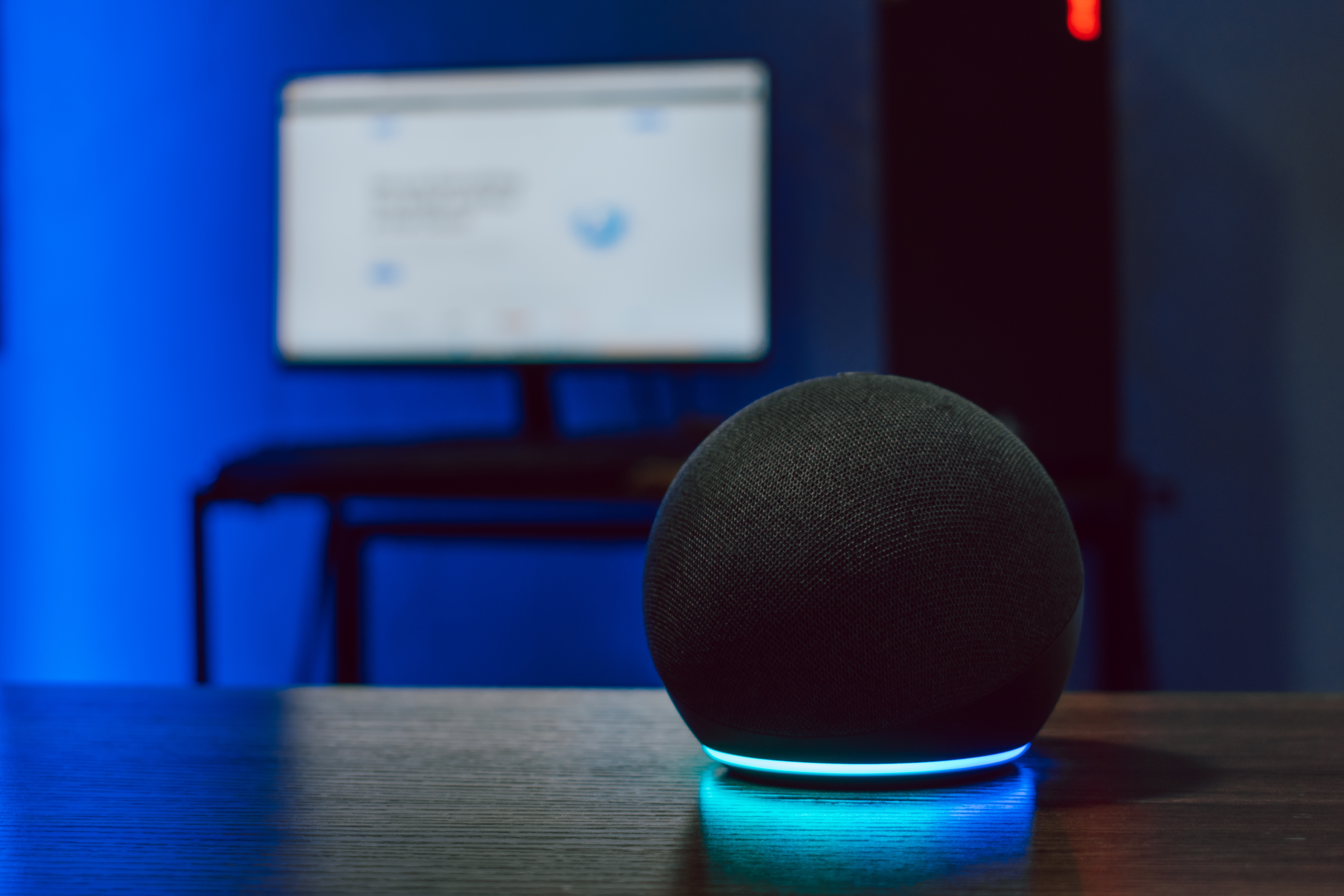 Sphere black speaker with glowing blue base in the foreground