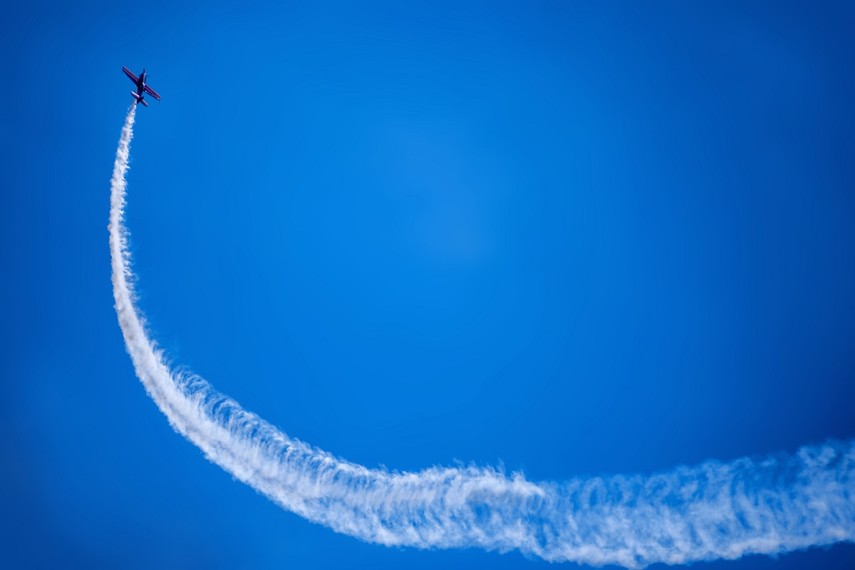 plane climbing with smoke trail at air show