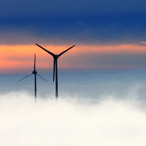 Power cuts avoided but price rises on the way silhouette of two wind turbines in mist with blue and orange morning sky