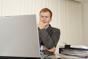 Busting the myths about switching business energy Man in front of laptop thinking hard.