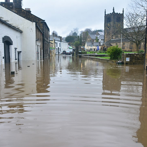 How to protect your home from flooding English village with houses half covered in flood water and church in background.
