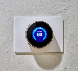 How to tackle the climate emergency from home blue thermostat dial set to 63 degrees on white wall