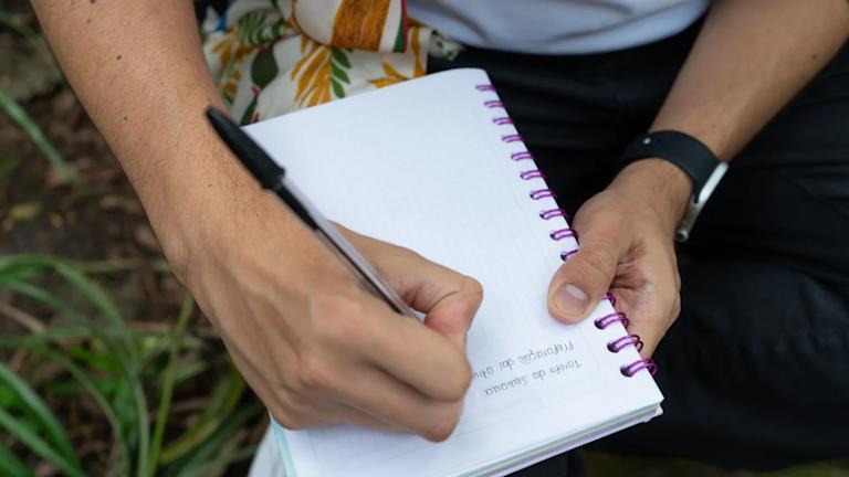 Persona escribiendo en cuaderno