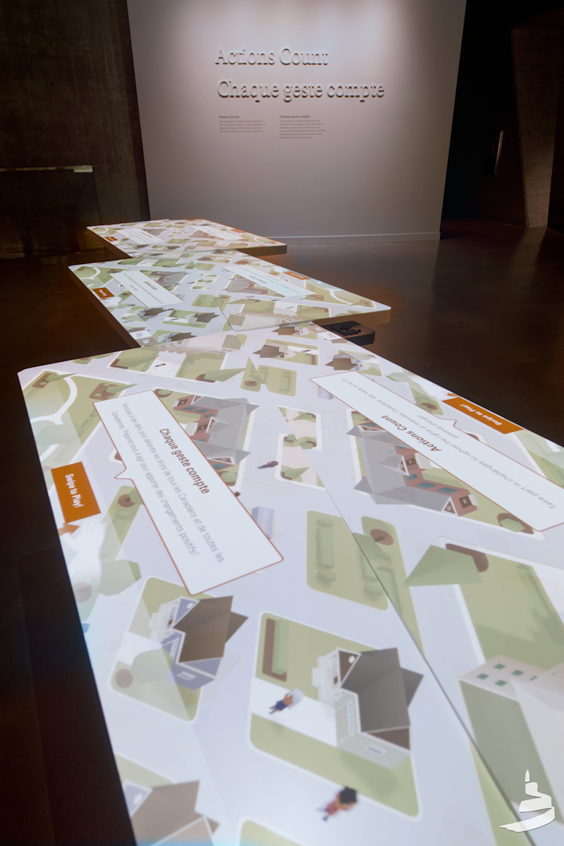 The fictional world is projected on a corian table with angled planes.