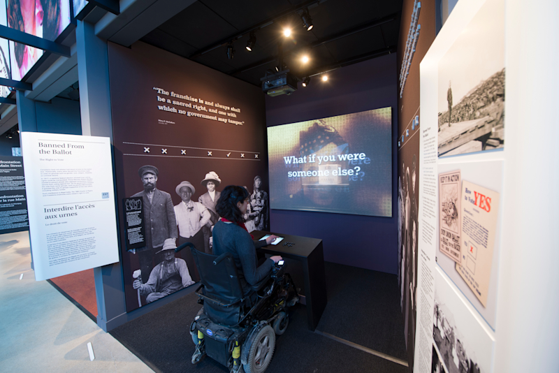 Screen showing questions for the visitor, with the ballot box artifact in the background.