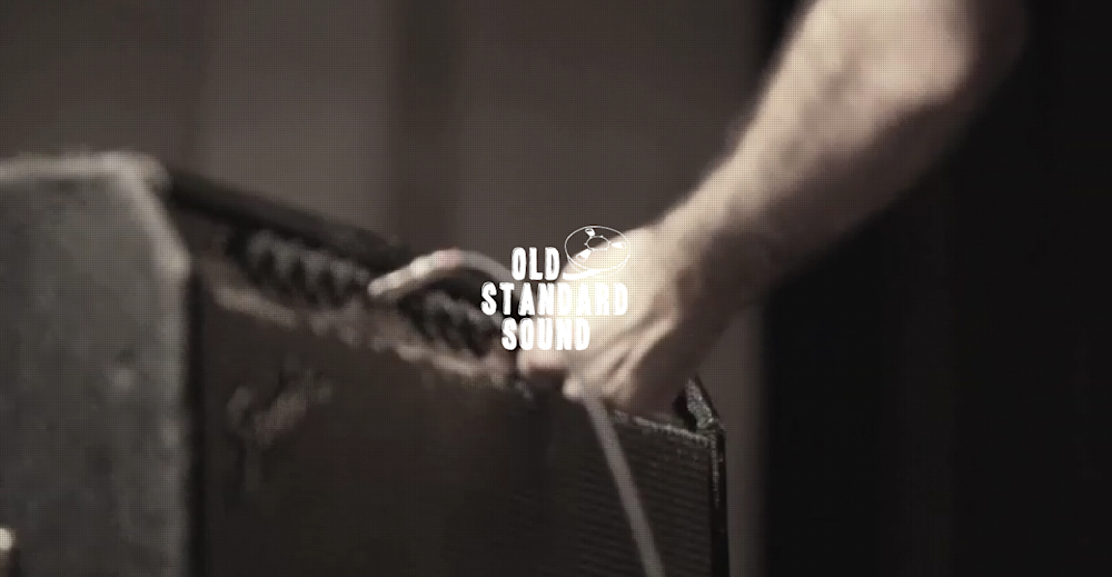 Screenshot from the Old Standard Sound website video showing a person plugging into an amplifier
