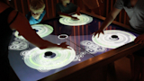 Visitors exploring harmonious sounds on the Circle of Fifths touch table.