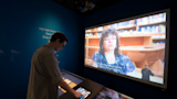Visitor interacting with touchscreen kiosk for language rights