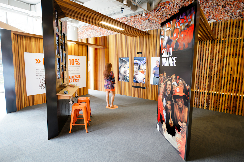 Visitor watching a three-screen Clemson Family Portrait video.