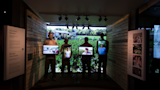 Screens carried by life-size replica of migrant workers.