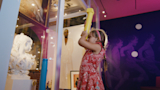 A young girl uses a custom-designed periscope to get a different view on artworks in the Wonder Studio Artquarium.