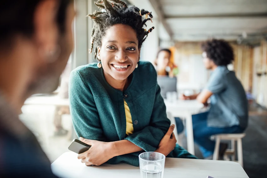 smiling woman sitting at a table in a cafe