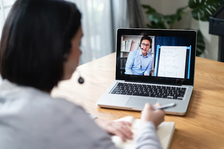 Woman on a laptop with a headset listening in a laptop