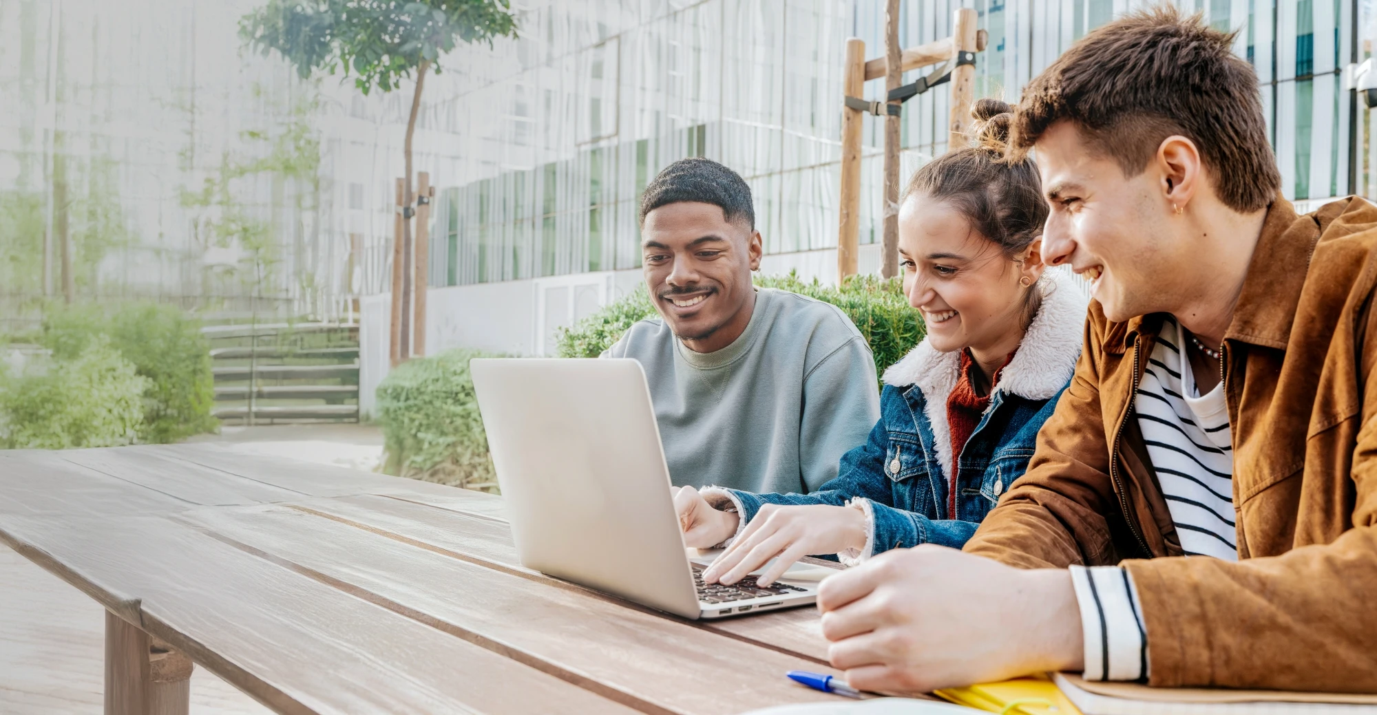 Three students studying together at a table outdoors
